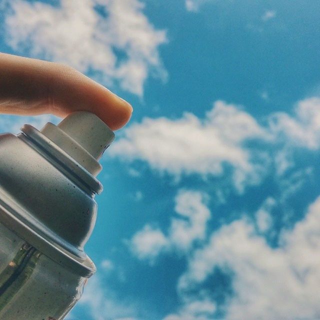 LOW ANGLE VIEW OF CROPPED HAND AGAINST THE SKY