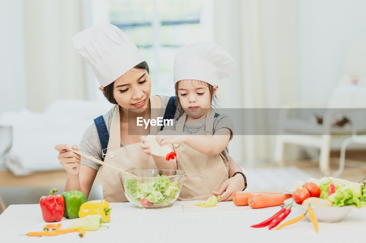MIDSECTION OF WOMAN PREPARING FOOD