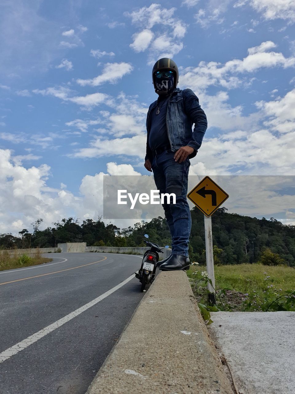 Low angle view of man wearing helmet standing against sky