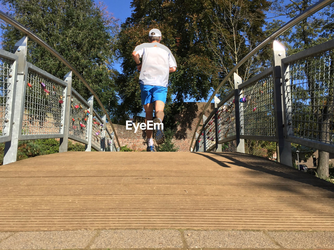 Rear view of man running on footbridge
