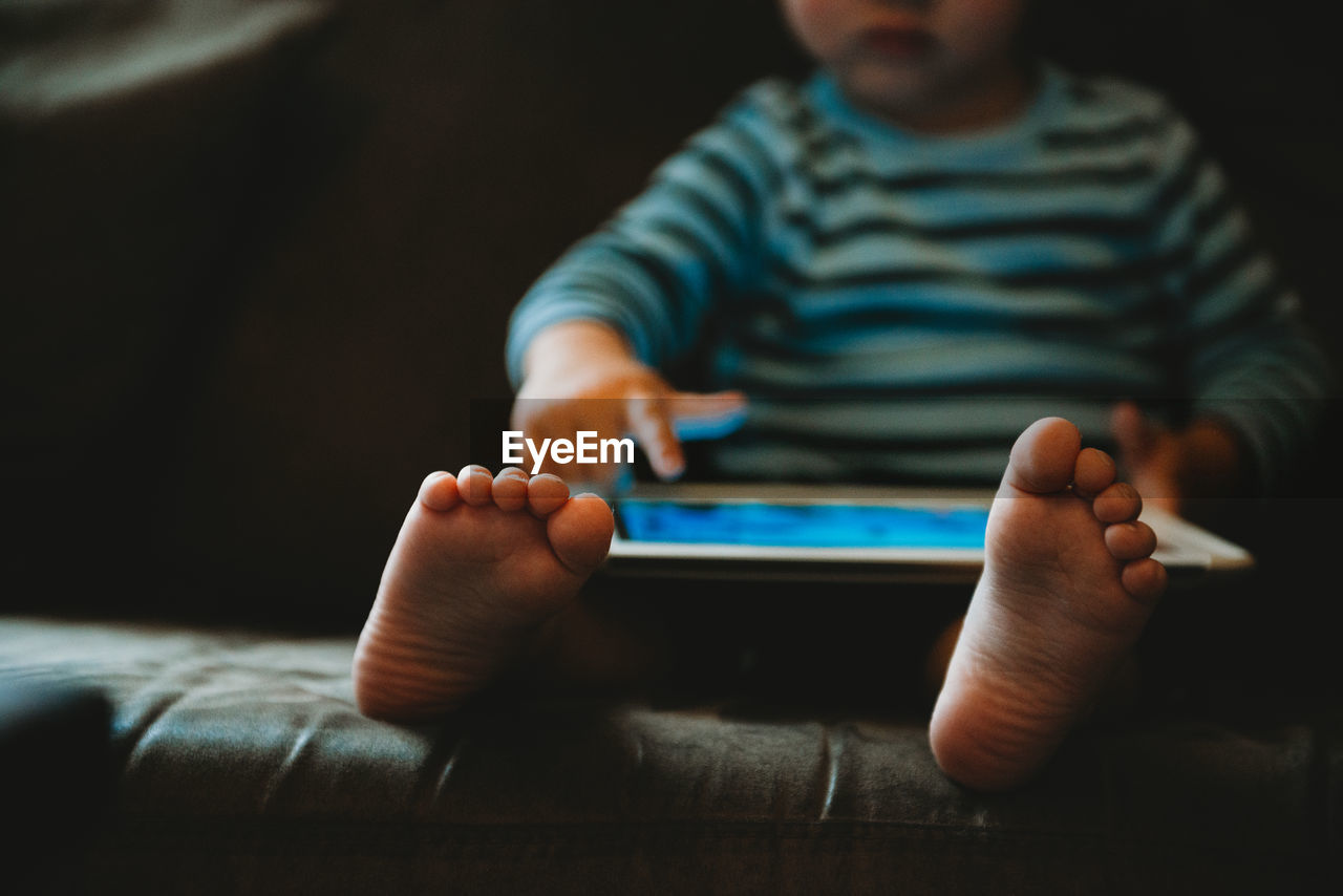 Young child playing with a tablet during isolation in quarantine