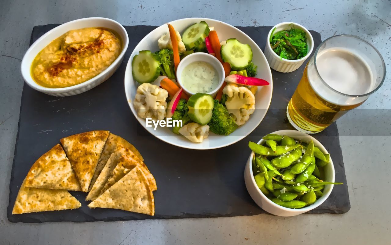 High angle view of vegetable platter and beer on table