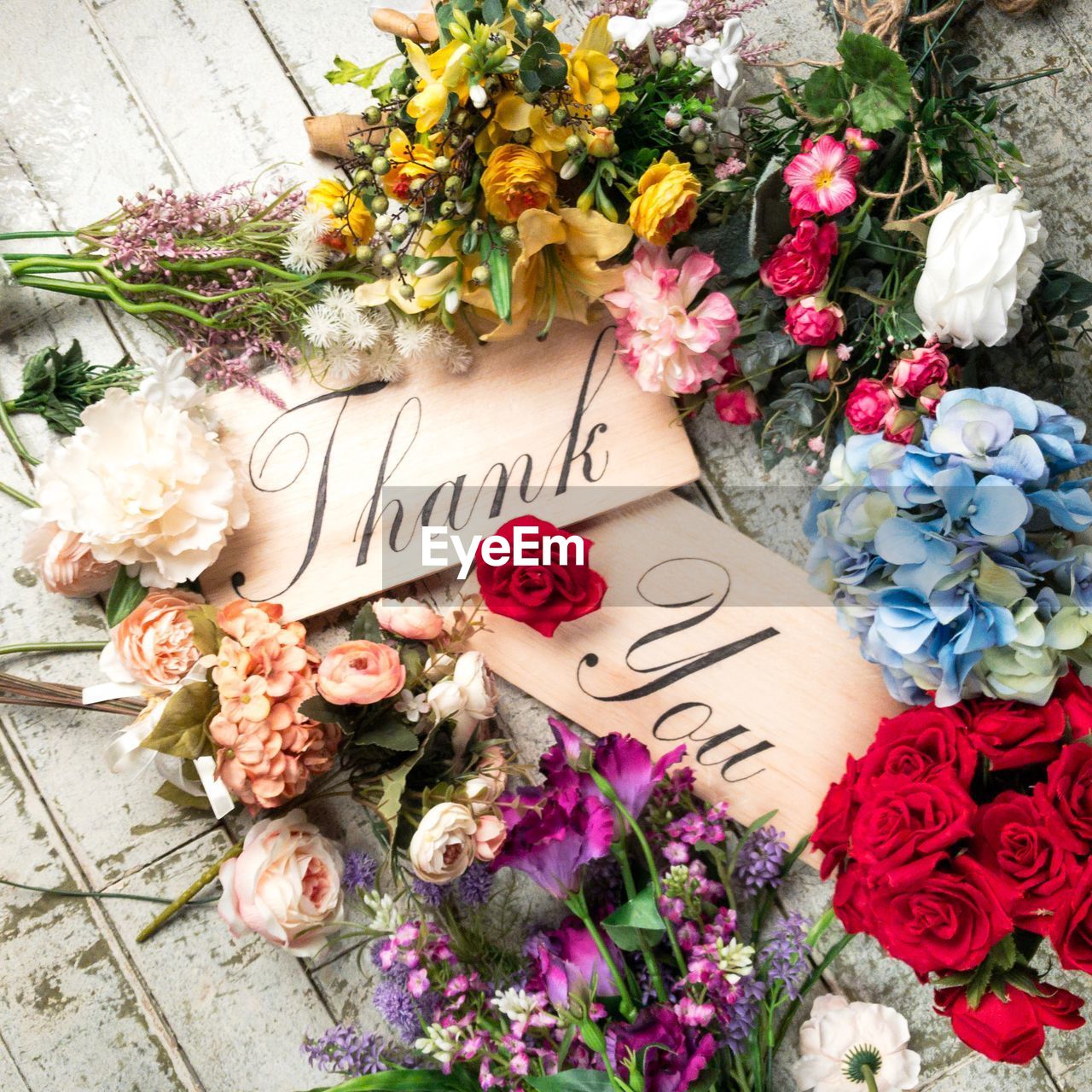 Directly above shot of various flowers and thank you sign on table