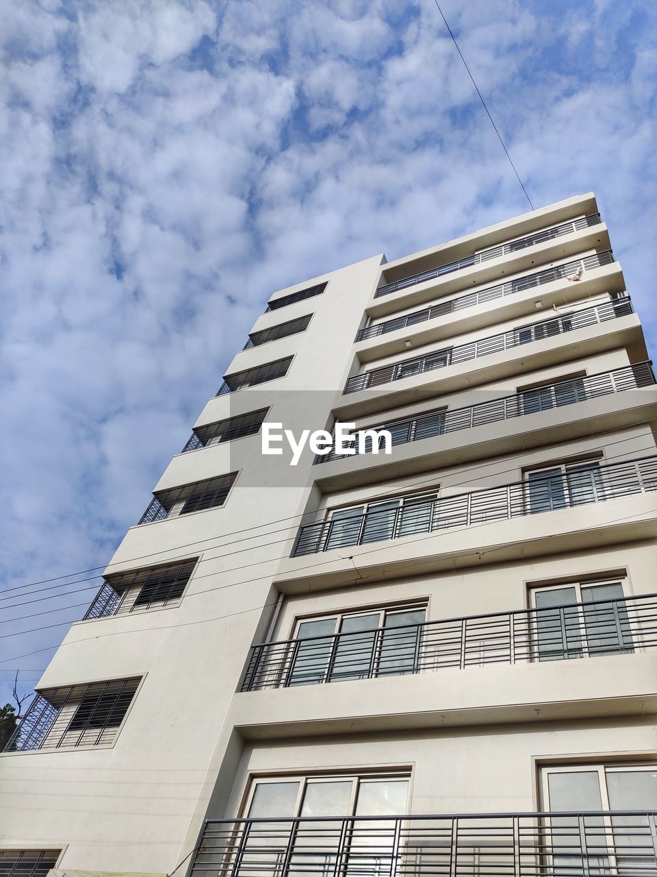 LOW ANGLE VIEW OF APARTMENT BUILDING AGAINST SKY