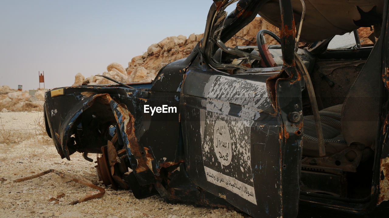 A destroyed isis car. isis flag. war on terror