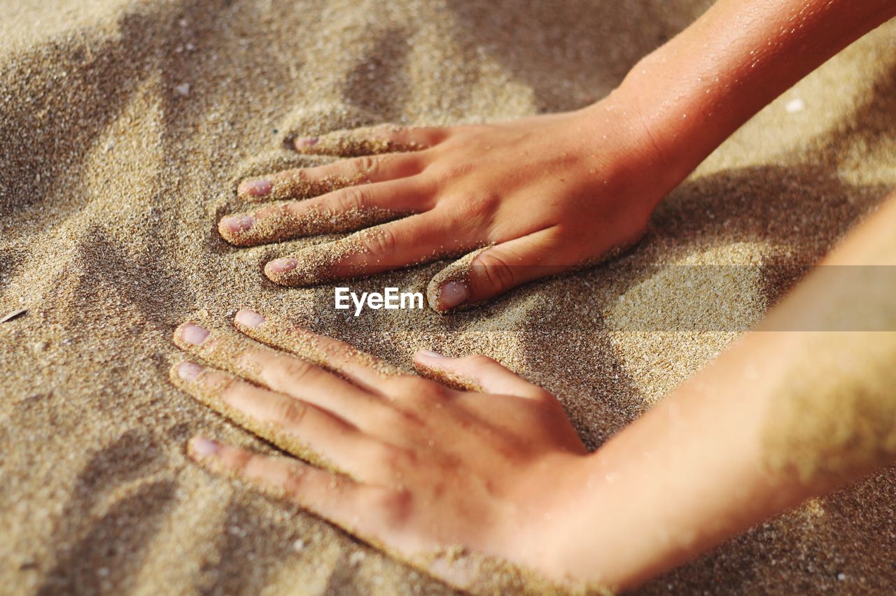 High angle view of hands at beach