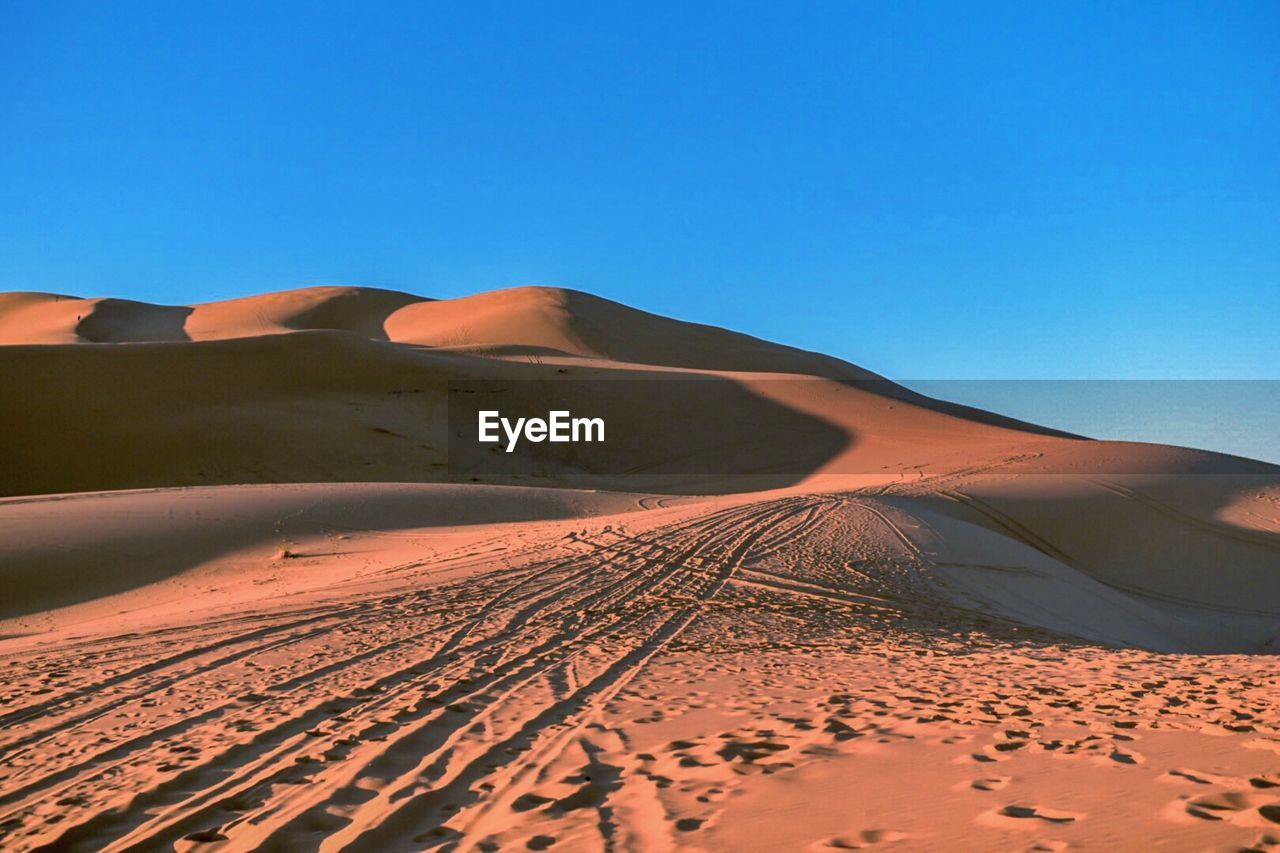 SAND DUNE IN DESERT AGAINST CLEAR BLUE SKY