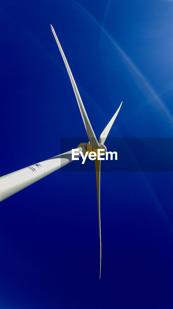 LOW ANGLE VIEW OF WIND TURBINE AGAINST CLEAR BLUE SKY