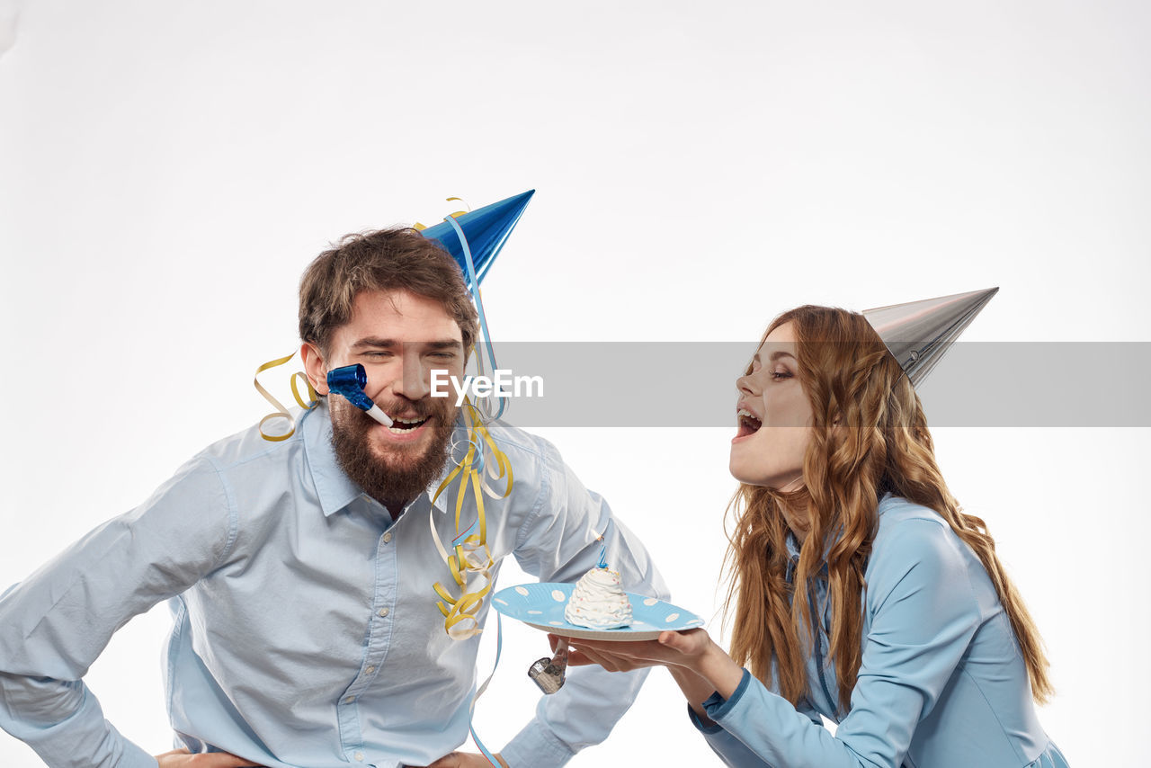 two people, adult, happiness, men, emotion, young adult, smiling, women, togetherness, positive emotion, cheerful, fun, friendship, enjoyment, copy space, communication, holding, laughing, indoors, person, graduation, bonding, white background, lifestyles, business, casual clothing, love, success, celebration, female, clothing