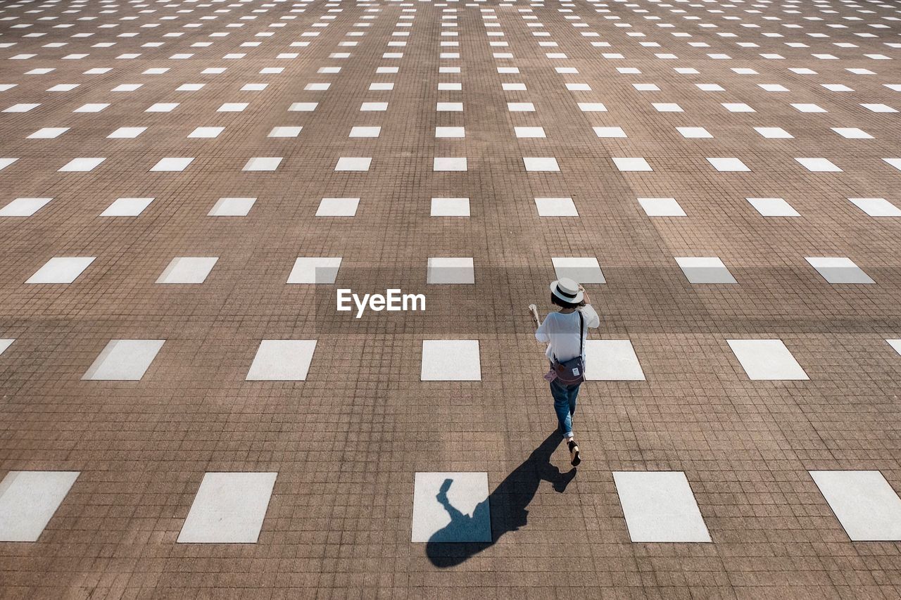 High angle view of woman walking on footpath