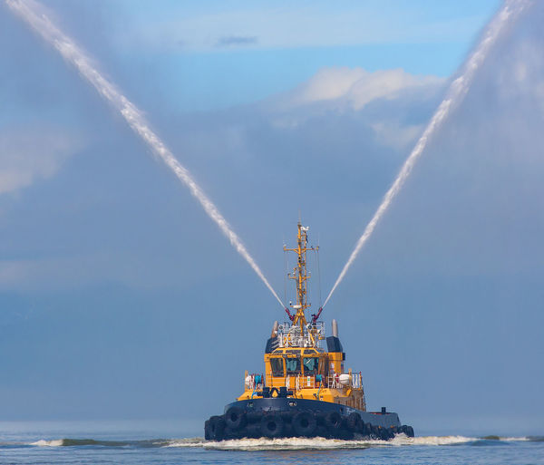 Fire hose boat spraying water on kamchatka on paciic ocean