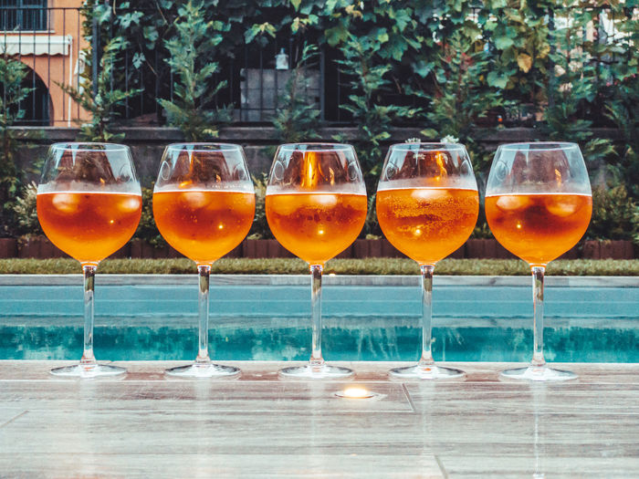 Close-up of aperol spritz against swimming pool