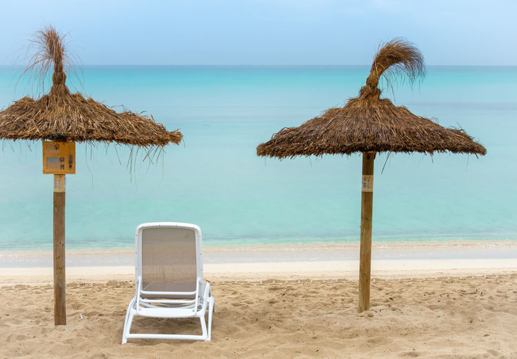 Thatched roofs and lounge chair at beach