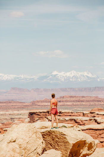 Strong tan female hiker looks at la sal mountains in the utah desert