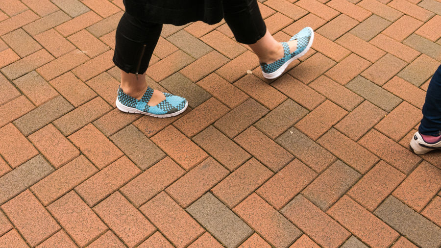 Low section of people standing on cobblestone