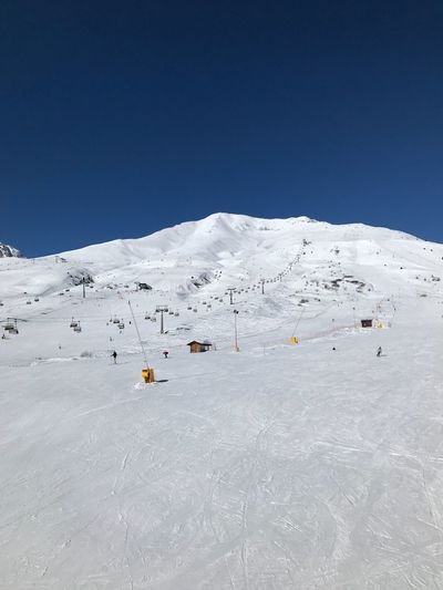 Scenic view of snowcapped mountains against clear blue sky