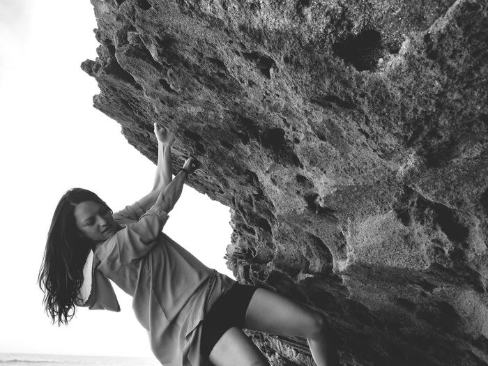 Tilt image of woman climbing on rock formation