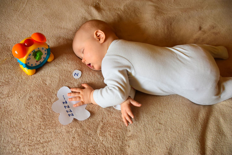 High angle view of cute baby lying on carpet