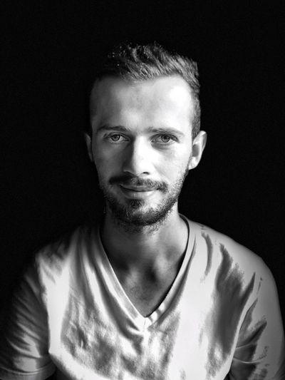 Portrait of smiling man against black background
