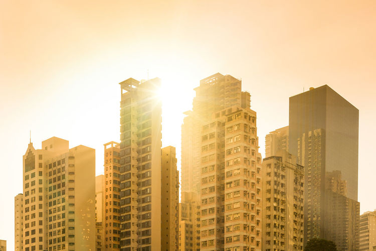 Sunset behind skyline of apartment buildings in the neighborhood of chung wan, hong kong, china.