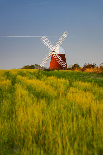 Traditional windmill on field against clear sky