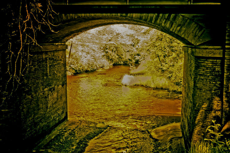 Arch bridge over river in tunnel