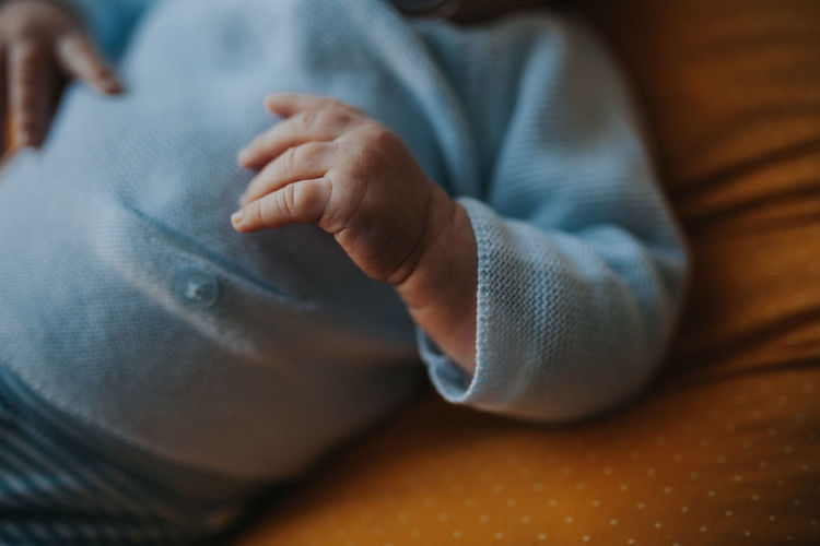 Midsection of baby boy lying on bed at home