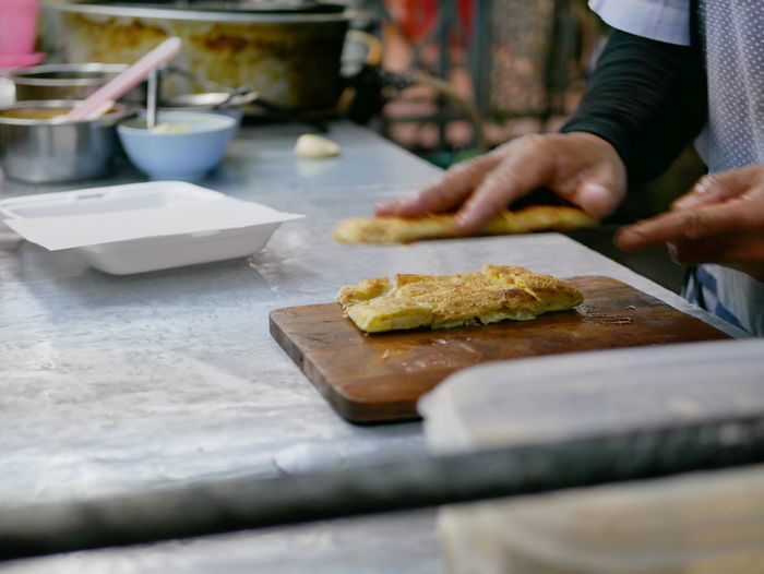 Crisp chopped roti being put in a box getting ready to be served - delicious street food in thailand