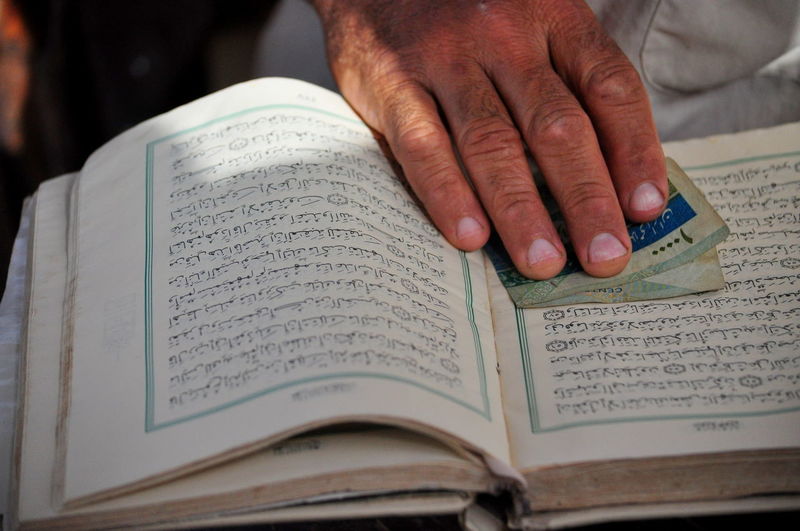 Close-up of man reading quran