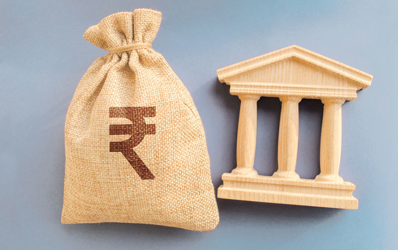 Indian rupee money bag and government building. business and finance concept.
