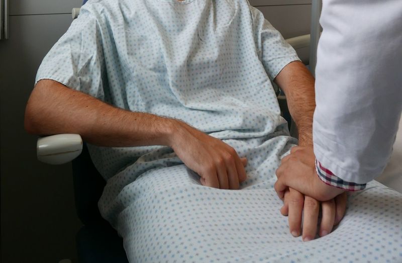 Cropped image of doctor comforting patient in hospital