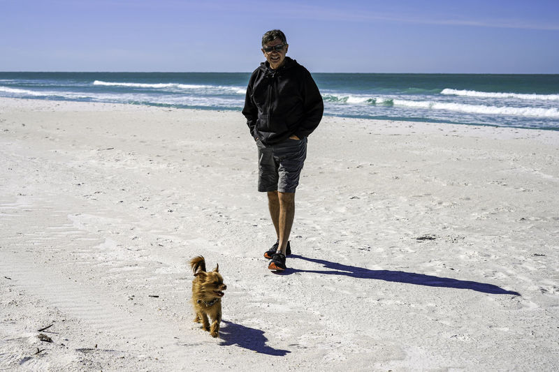 Man and his dog going for a beach walk