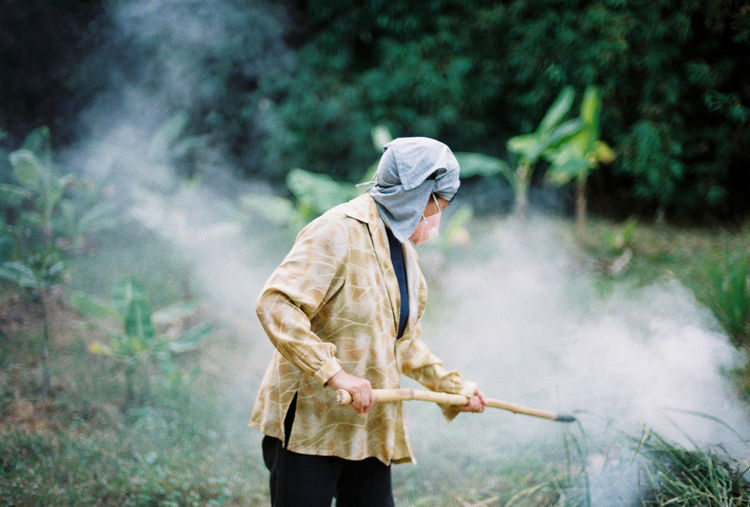 Man holding umbrella while standing on land