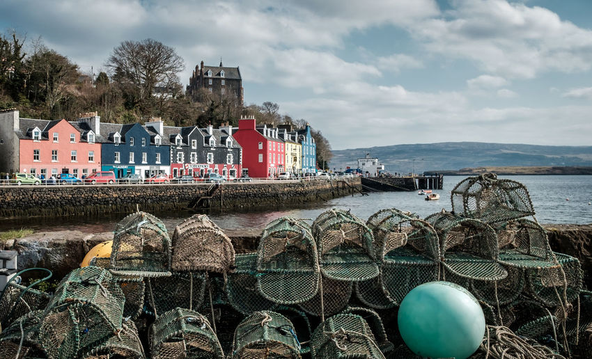 Scenic view of lobster traps against colourful village of tobermory