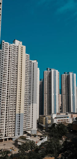 Modern buildings in city against clear blue sky