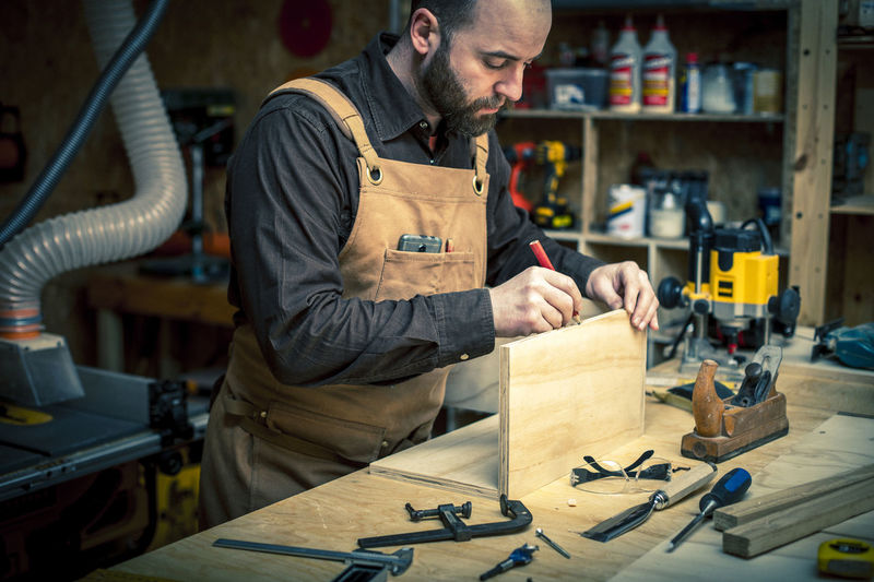 Man marking on wood in workshop