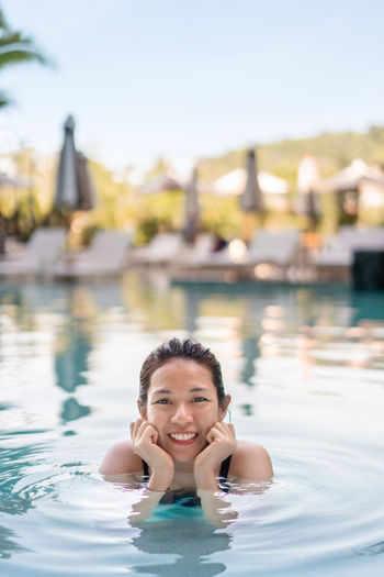 Portrait of a smiling young woman swimming in pool