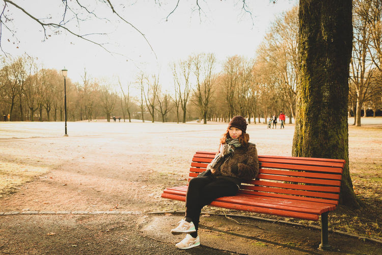 Woman sitting on bench in park