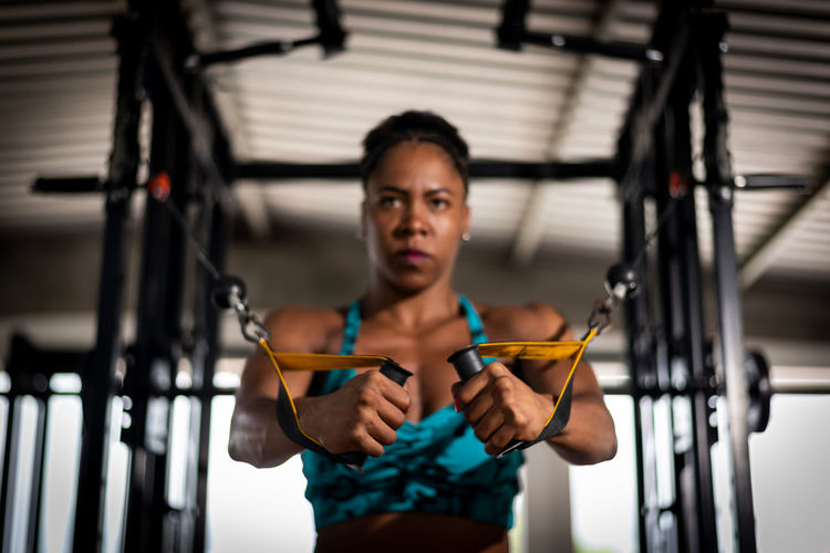 Muscular woman doing arm exercises on a machine at the gym. determination and focus.