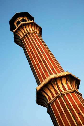 Low angle view of historic column against clear blue sky