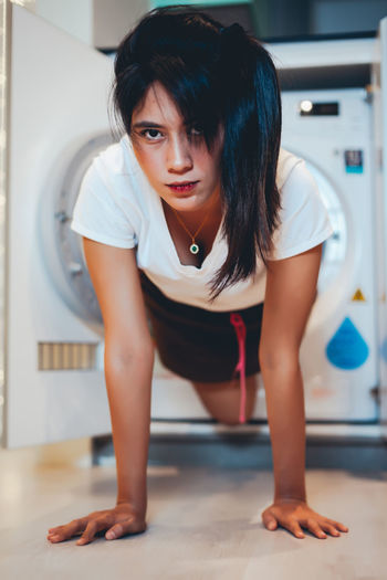 Woman coming out from washing machine at home