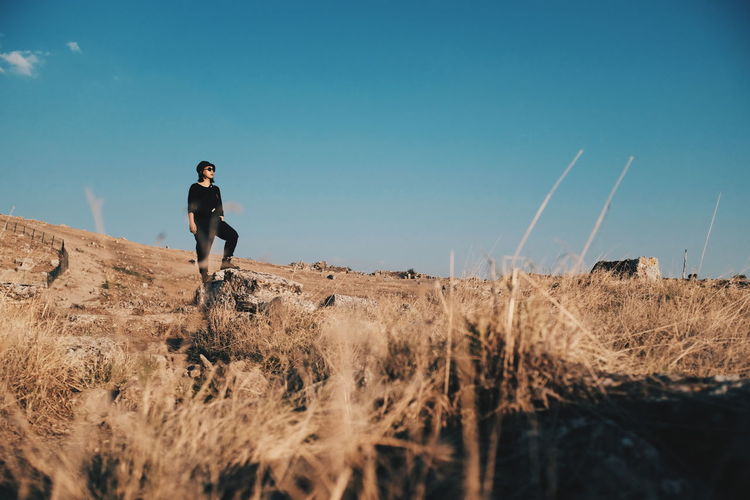 Woman standing on field against sky