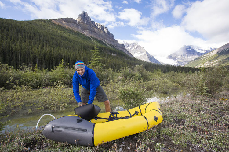 Excited man inflates his packraft before paddling the alexandra river.