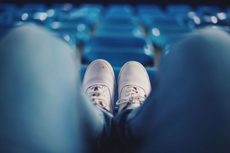 Low section of man sitting on chair at stadium