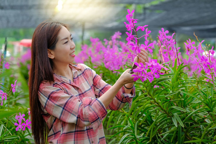 Young woman blowing flowers