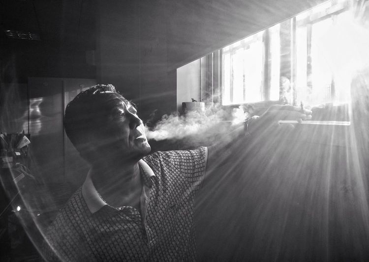Mid adult man smoking indoors