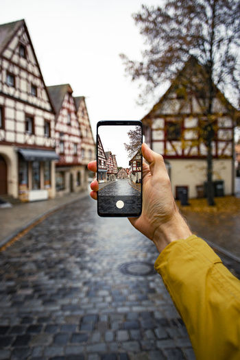 Man photographing with mobile phone in old town in germany