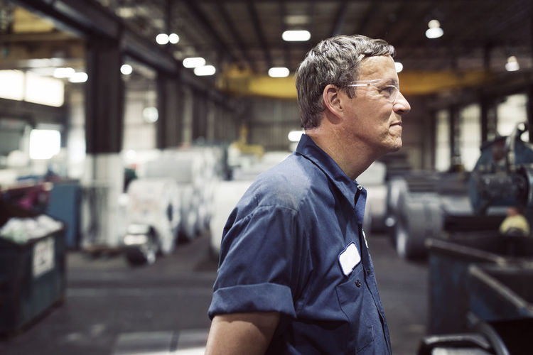 Side view of blue collar worker looking away in steel industry
