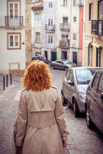 Rear view of woman standing on street in city