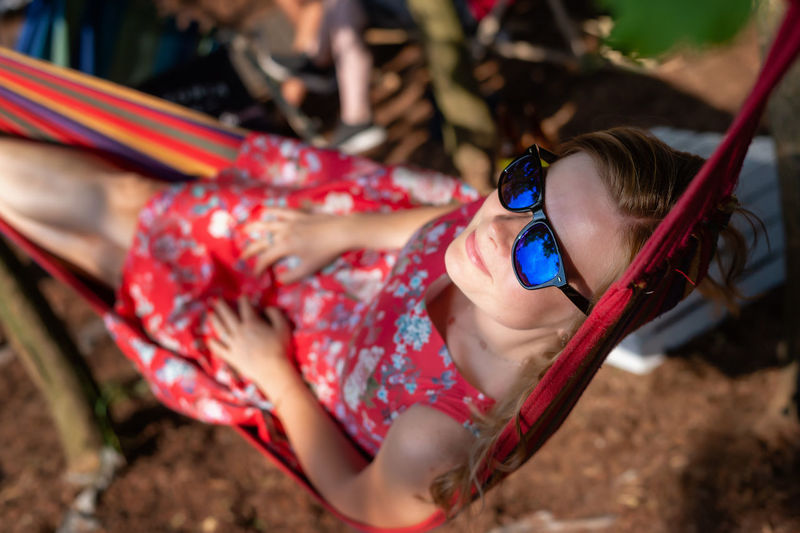 Outdoor portrait of woman relaxing in the hammock in the summer garden